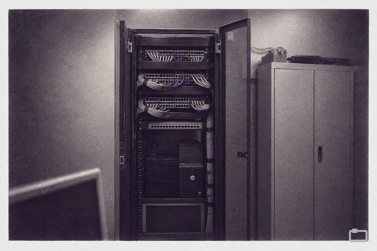 Mezzotint of an open rack with patch panels and neat cables